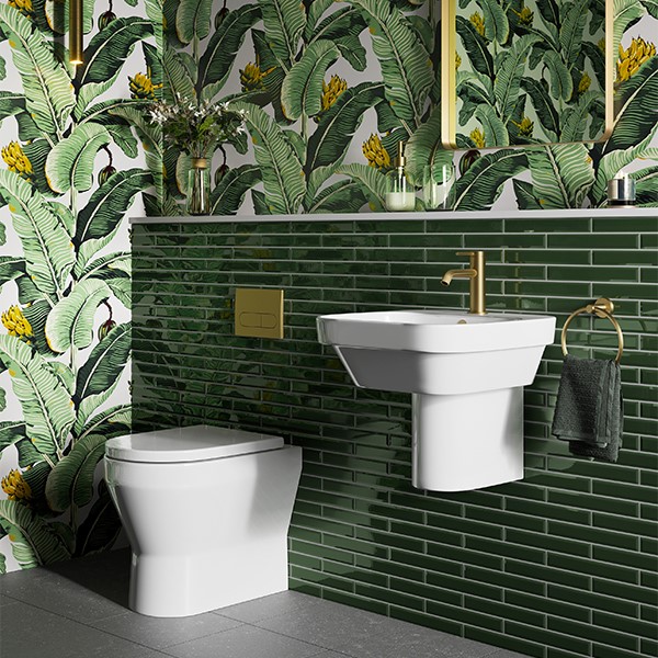 A striking green colourful bathroom with brushed brass brassware